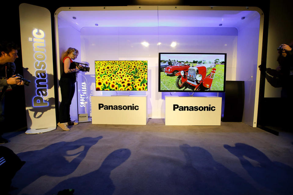 Show attendees photograph Panasonic's new televisions during a news conference at the International Consumer Electronics Show.