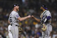 Colorado Rockies starting pitcher Jon Gray, left, bumps fists with catcher Elias Diaz as he is removed from the baseball game against the San Diego Padres in the seventh inning Friday, July 30, 2021, in San Diego. (AP Photo/Derrick Tuskan)