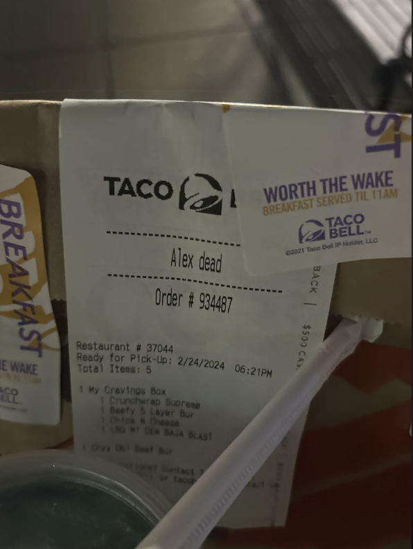 Receipt from Taco Bell for an order dated 2/04/2044, partially obstructed and held in place by a straw wrapper