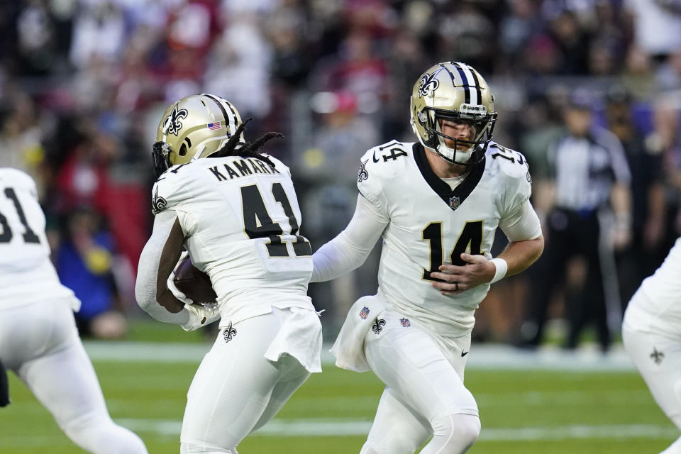 New Orleans Saints quarterback Andy Dalton (14) hands off to running back Alvin Kamara (41) during the first half of an NFL football game, against the Arizona Cardinals Thursday, Oct. 20, 2022, in Glendale, Ariz. (AP Photo/Ross D. Franklin)