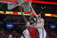 New Orleans Pelicans forward Brandon Ingram (14) goes to the basket between Oklahoma City Thunder guard Luguentz Dort (5) and forward Chet Holmgren (7) in the first half of Game 3 of an NBA basketball first-round playoff series in New Orleans, Saturday, April 27, 2024. (AP Photo/Gerald Herbert)
