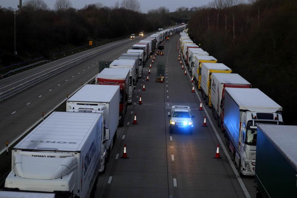 Trucks are parked up on the M20, part of Operation Stack in Ashford, Kent, England, Friday, Dec. 25, 2020. Thousands wait to resume their journey across The Channel after the borders with France reopened. Trucks inched slowly past checkpoints in Dover and headed across the Channel to Calais on Thursday after France partially reopened its borders following a scare over a rapidly spreading new virus variant. (AP Photo/Kirsty Wigglesworth)