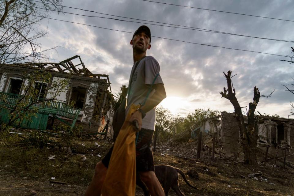 A man walks past homes damaged by a rocket attack in Kramatorsk, Ukraine, in August 2022 (David Goldman/AP)