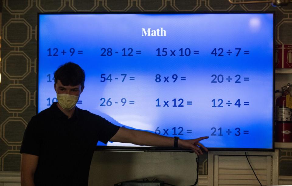 Eddie Nash points to a big lighted screen with math problems on it.