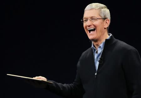 Apple CEO Tim Cook shows the new MacBook during an Apple event in San Francisco, California March 9, 2015. REUTERS/Robert Galbraith