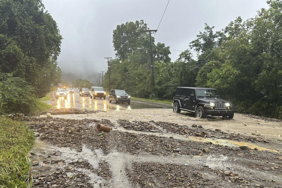 Vehicles maneuver around a mudslide caused by heavy rains along U.S. Route 60 on Monday, Aug. 28, 2023, in Cedar Grove, W.V. (Ava Rash/WCHS-TV via AP)