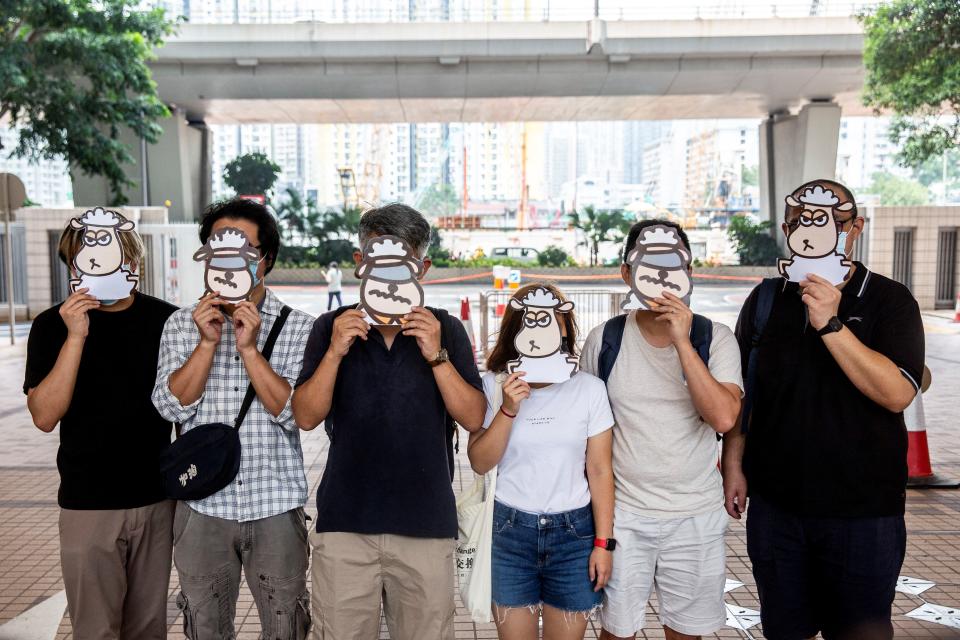 Supporters of a pro-democracy union pose with illustrations of sheep outside West Kowloon Court in Hong Kong on July 23, 2021, where members of the union face charges of sedition for publishing children's books which allegedly try to explain the city's democracy movement using illustrations of sheep.
