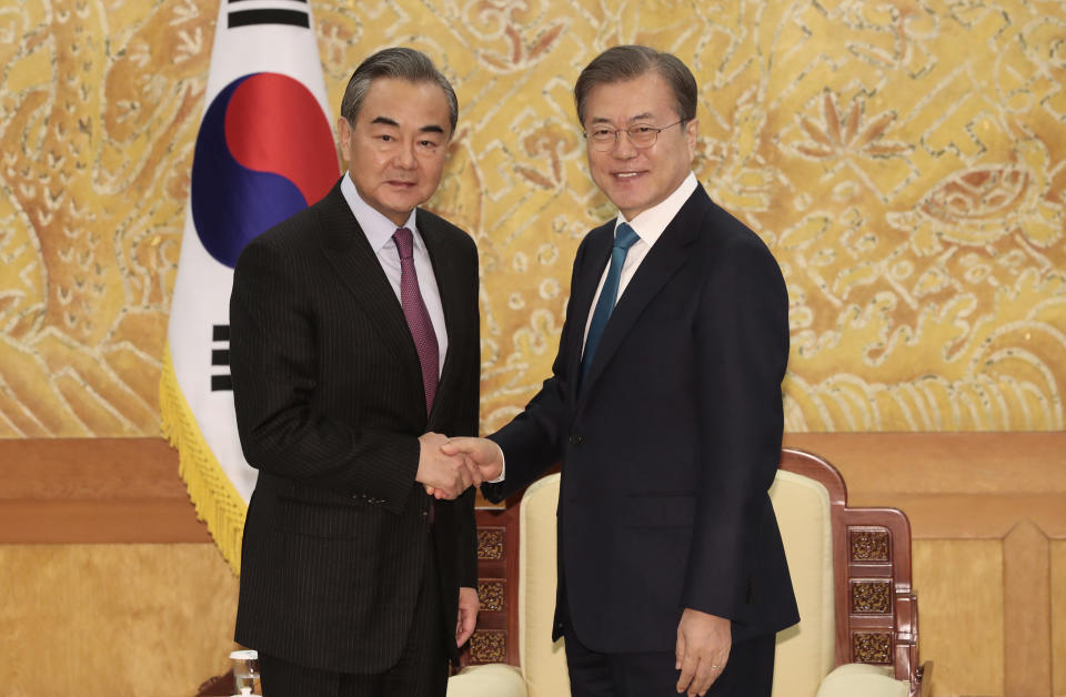 South Korean President Moon Jae-in, right, shakes hands with Chinese Foreign Minister Wang Yi during a meeting at the presidential Blue House in Seoul, South Korea, Thursday, Dec. 5, 2019. Wang arrived in South Korea on Wednesday for his first visit in four years amid efforts to patch up relations damaged by Seoul's decision to host a U.S. anti-missile system that Beijing perceives as a security threat. (Lee Jin-wook/Yonhap via AP)