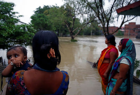 A woman carrying her child looks toward the flood affected area in Janakpur, Nepal August 13, 2017. REUTERS/Navesh Chitrakar