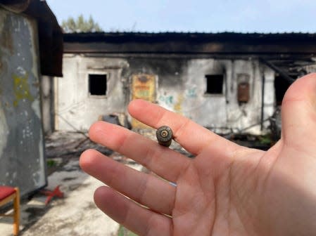 Slava Bazarsky holds a bullet while giving a tour of a kibbutz