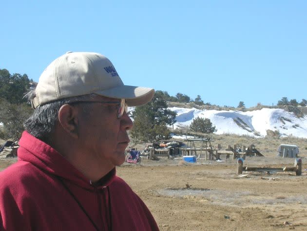 Teddy Nez stands on his property adjacent to the Northeast Church Rock Mine in northwestern New Mexico in 2008. Behind him is a 50-foot uranium waste pile from mining operations.