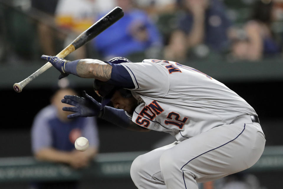 Houston Astros' Martin Maldonado ducks out of the way of a pitch from Baltimore Orioles reliever Tayler Scott during the seventh inning of a baseball game Saturday, Aug. 10, 2019, in Baltimore. Maldonado's bat made contact with the ball and it rolled into fair territory; Scott threw him out at first base. (AP Photo/Julio Cortez)