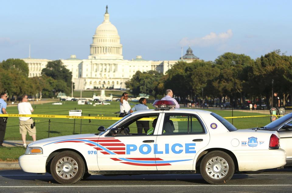 A Washington police car arrives at the scene where a man set himself on fire near the U.S. Capitol on the U.S. National Mall in Washington