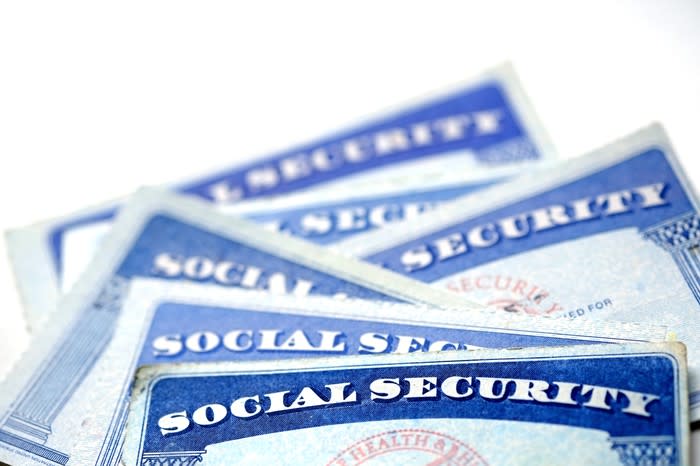 A half dozen Social Security cards in a messy pile.