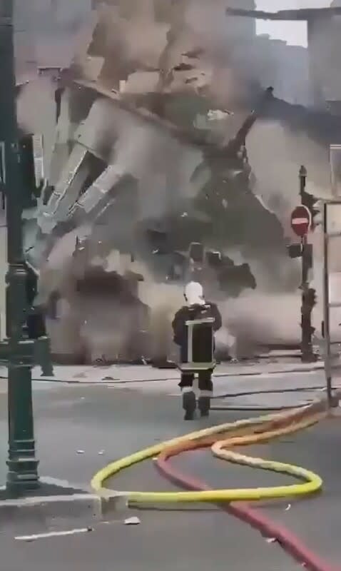 一棟被燒到焦黑的建築物，在突然間產生裂痕並崩塌，一旁的消防隊員被嚇了一跳，發出驚慌的叫聲。   圖：翻攝自NEXTA推特