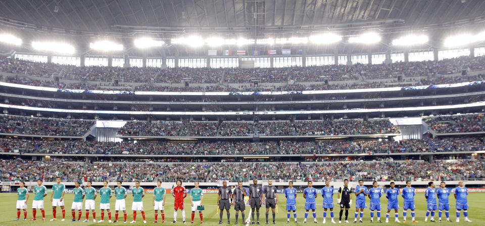 Mexico, left, officials, center, and El Salvador stand at attention during the playing of their respective national anthems before the start of a CONCACAF Gold Cup soccer match at Cowboys Stadium on Sunday, June 5, 2011 in Arlington, Texas. (AP Photo/Brandon Wade)