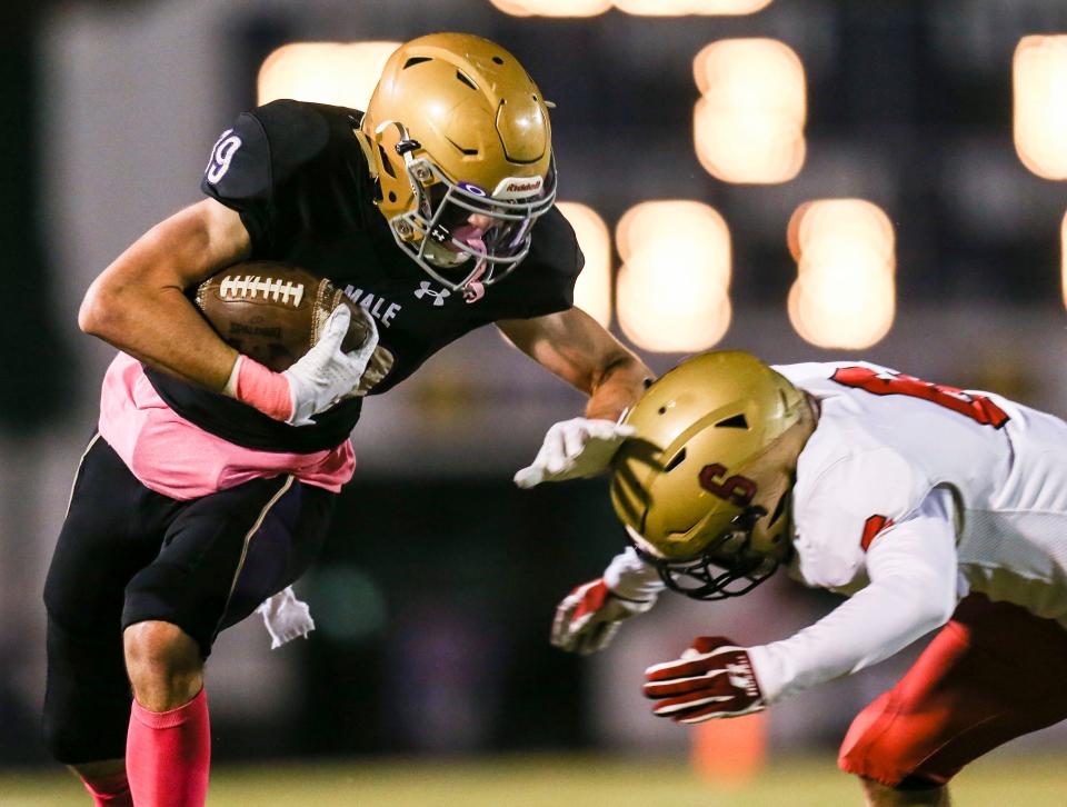 Male's Dominic Vrbancic runs for yardage after a catch against Bullitt East in the first half Friday night. Oct. 22, 2021