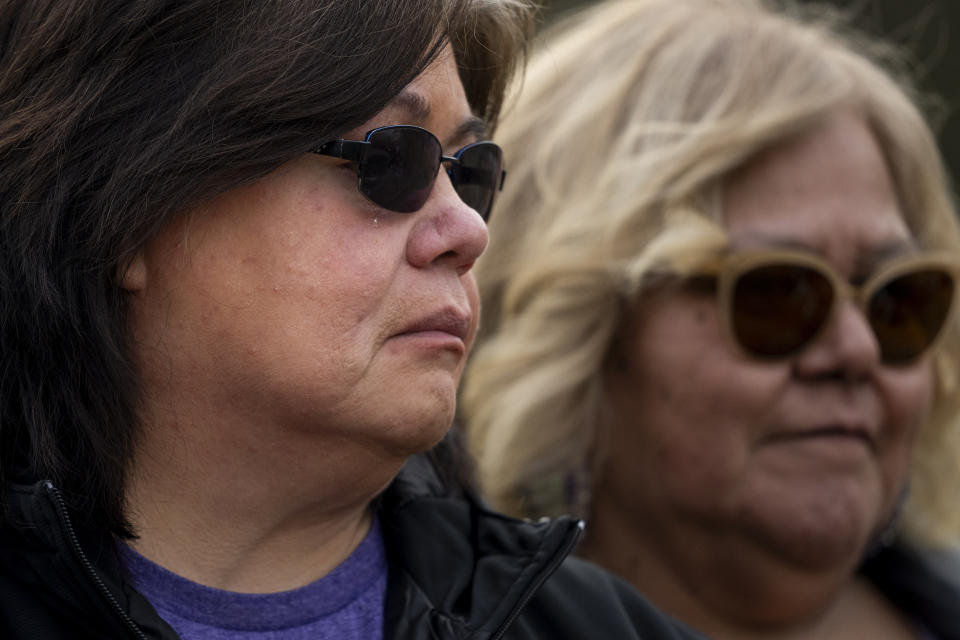 Lummi Nation crisis outreach supervisor Evelyn Jefferson, left, sheds a tear while talking about her son Patrick George Jr., who died last September due to an overdose of drugs containing the synthetic opioid carfentanil, as she stands with her sister Maria Hillaire, right, at the Lummi Nation cemetery on tribal reservation lands, Thursday, Feb. 8, 2024, near Bellingham, Wash. Jefferson had to wait a week to bury her son due to several other overdose deaths in the community. (AP Photo/Lindsey Wasson)