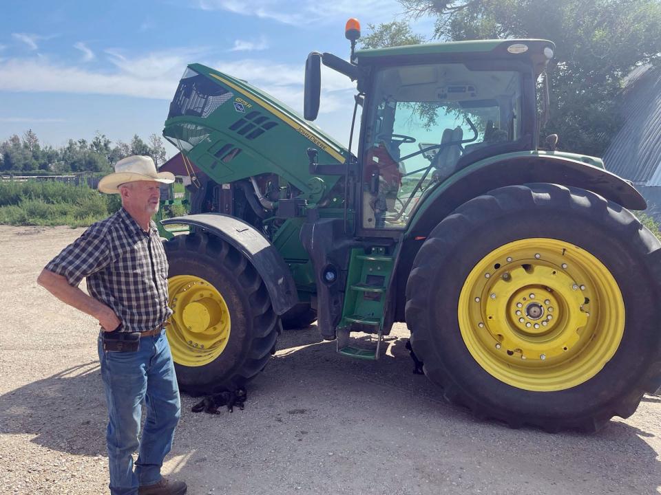 Don Zilverberg, 75, stands in front of his John Deere tractor at the Bar JZ North Ranch in Holabird on July 24.