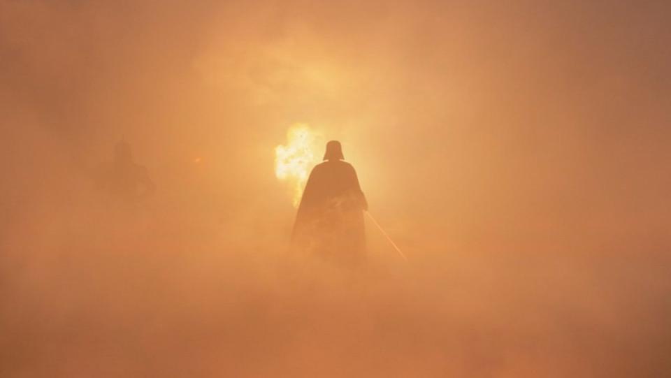 Darth Vader walks through an orange mist in battle on Ahsoka