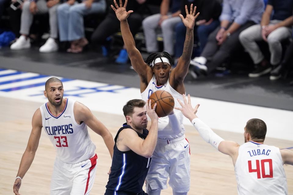 Los Angeles Clippers' Nicolas Batum (33), Terance Mann, rear, and Ivica Zubac (40) defend as Dallas Mavericks guard Luka Doncic, bottom center, moves to the basket in the second half in Game 3 of an NBA basketball first-round playoff series in Dallas, Friday, May 28, 2021. (AP Photo/Tony Gutierrez)