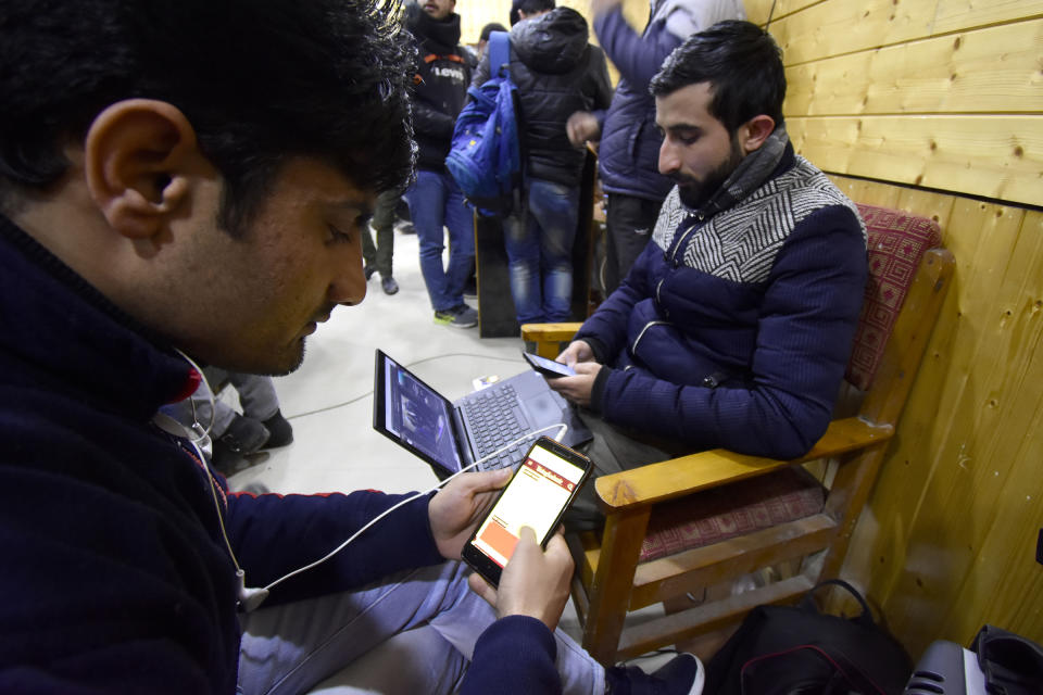 Kashmiri people look at their mobile phones after authorities restored low speed mobile internet services in the Kashmir Valley on Jan. 25, 2020. | Muzamil Mattoo—NurPhoto via Getty Images