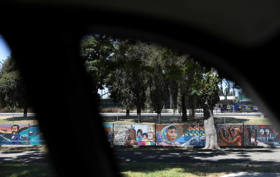 A mural is seen through a car window.