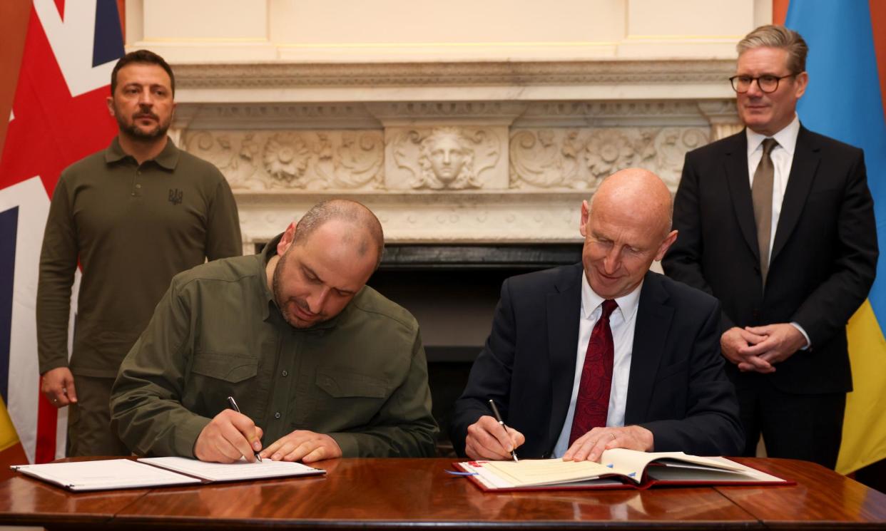 <span>The defence secretary, John Healey, signs a credit agreement with Ukraine’s defence minister, Rustem Umerov, in London on 19 July 2024, as Keir Starmer (standing, right) and Volodymyr Zelenskiy look on.</span><span>Photograph: Lauren Hurley/No 10 Downing Street</span>