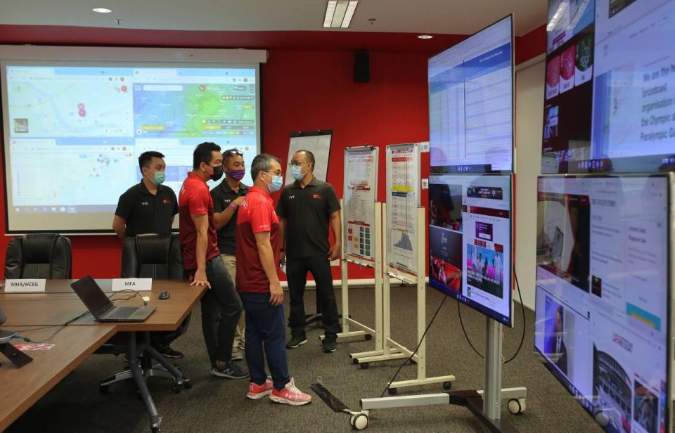 Minister for Culture, Community and Youth Edwin Tong (centre, red shirt) at the Crisis Ops Centre set up for Team Singapore athletes going to the Tokyo Olympics. (PHOTO: Facebook/Edwin Tong)