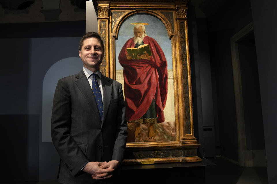 Chief Curator of the Isabella Stewart Gardner Museum Nathaniel Silver poses next to the Italian artist Piero della Francesca's St. John the Evangelist painting on the occasion of the inauguration of the exhibit "Piero della Francesca. Il Polittico Agostiniano riunito" (Piero della Francesca. The Augustinian Polyptych reunited) at Milan's Poldi Pezzoli museum, Italy, Tuesday, March 19, 2024. The Augustinian altarpiece originally comprised 30 sections in a polyptych, was dismantled after the Augustinians moved churches and eventually sold off. Only eight of the sections remain as individual paintings owned by museums in New York, Washington, D.C., London, Milan and Lisbon, Portugal. (AP Photo/Antonio Calanni)