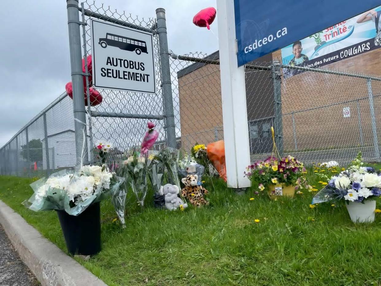 Flowers, balloons and stuffed animals outside a school at the corner of St-Joseph and Chéné streets in Rockland May 14, 2024. A child was struck and killed around that intersection the day before. (Joseph Tunney/CBC - image credit)