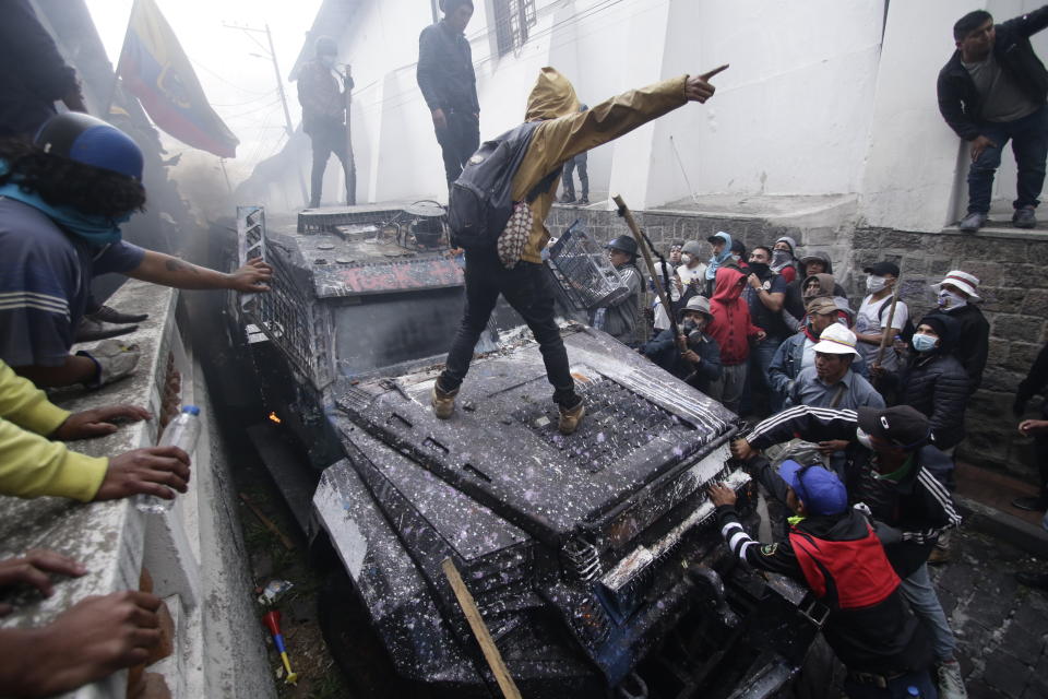 Anti-government demonstrators commandeer an armored vehicle during a nationwide strike against President Lenin Moreno and his economic policies , in Quito, Ecuador, Wednesday, Oct. 9, 2019. Ecuador's military has warned people who plan to participate in a national strike over fuel price hikes to avoid acts of violence. The military says it will enforce the law during the planned strike Wednesday, following days of unrest that led Moreno to move government operations from Quito to the port of Guayaquil. (AP Photo/Carlos Noriega)