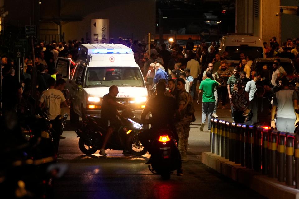 People gathering around an ambulance carrying the wounded (AP)