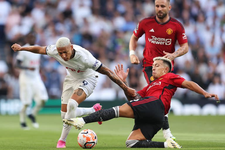 Richarlison intenta avanzar para Tottenham, pero se cruza Lisandro Martinez en su camino yendo al piso.