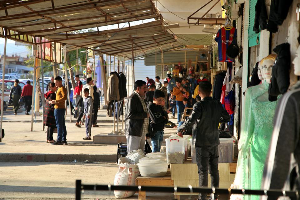 Crowds gather in the city center after a federal government order restored the central government's authority in Sinjar, Iraq. Friday Dec. 24, 2020. A new agreement aims to bring order to Iraq's northern region of Sinjar, home to the Yazidi religious minority brutalized by the Islamic State group. Since IS's fall, a tangled web of militia forces have run the area, near the Syrian border. Now their flags are coming down, and the Iraqi military has deployed in Sinjar for the first time in nearly 20 years. (AP Photo/Samya Kullab)