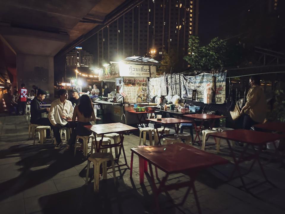 Clubbers eating at street food stalls.