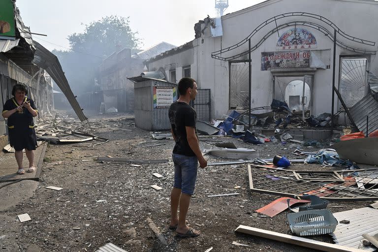 Residentes observan negocios destruídos luego de un ataque con cohetes en Sloviansk, 3 de julio de 2022. 