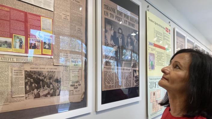 Rajna Dattani looking at newspaper clippings at an exhibition