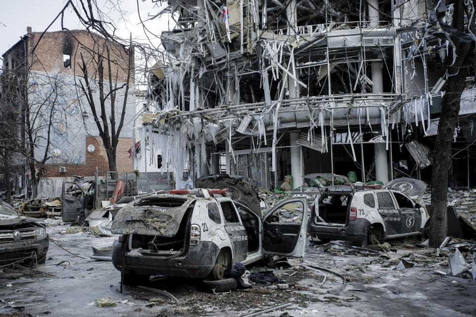 Damaged vehicles sit among debris and in Kharkiv city center in Ukraine, Wednesday, March 16, 2022. (AP Photo/Pavel Dorogoy)