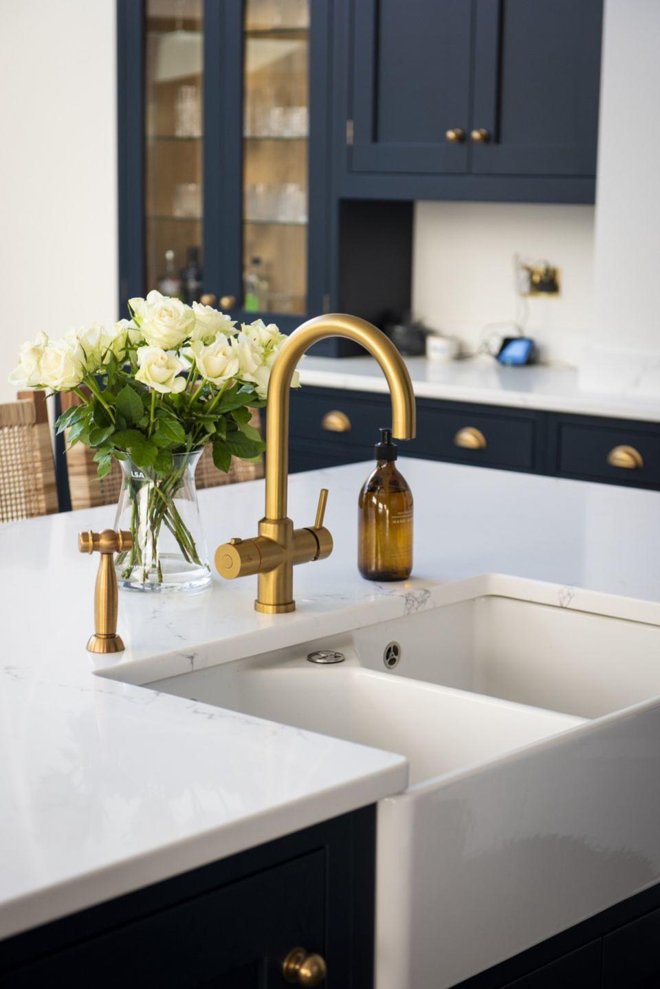 a vase of flowers on a sink