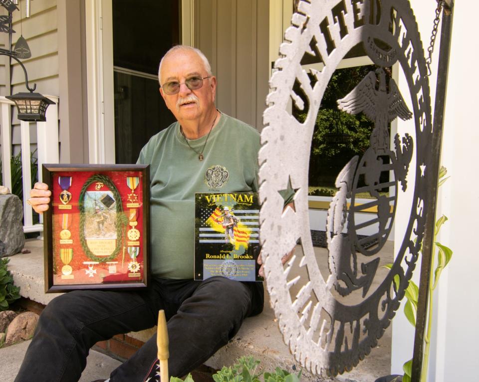 In his right hand Ron Brooks holds a display of medals including the Purple Heart he earned while serving as a U.S. Marine in Vietnam. He also holds a plaque presented to him by the American Legion Hall for his service in Vietnam, shown Monday, June 27, 2022.