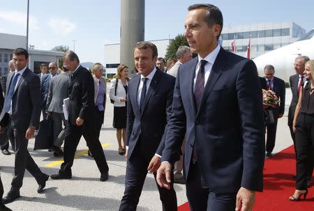 French President Emmanuel Macron is welcomed by Austrian chancellor Christian Kern at the airport in Salzburg, Austria, August 23, 2017. REUTERS/Heinz-Peter Bader