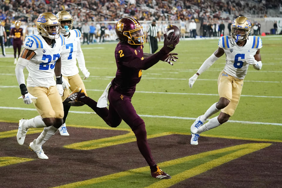 Arizona State wide receiver Elijhah Badger (2) makes a one-handed touchdown catch between UCLA defensive backs Kenny Churchwell III (23), Mo Osling III (7), and John Humphrey (6) during the second half of an NCAA college football game in Tempe, Ariz., Saturday, Nov. 5, 2022. UCLA won 50-36. (AP Photo/Ross D. Franklin)