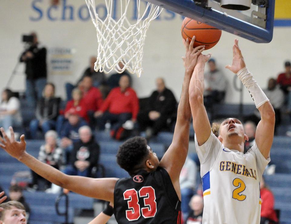 Wooster Micah McKee has this shot blocked by New Phila's Jadan Lowery