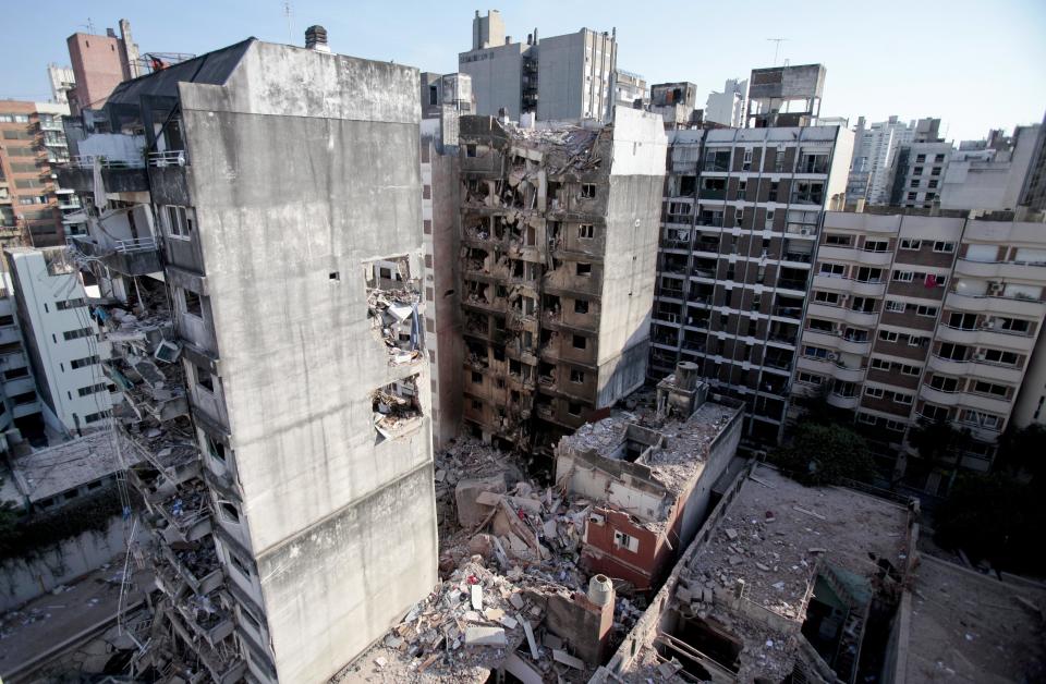 This view shows two other towers, in front of and behind a 10-story apartment building destroyed by a Tuesday gas explosion that killed 10 people, in Rosario, Argentina, Wednesday, Aug. 7, 2013. Argentine firefighters found signs of life Wednesday, searching through a huge pile of rubble, all that was left of a 10-story apartment building destroyed by a gas explosion that injured dozens and left 13 unaccounted for. (Alejandro Rio/AP)