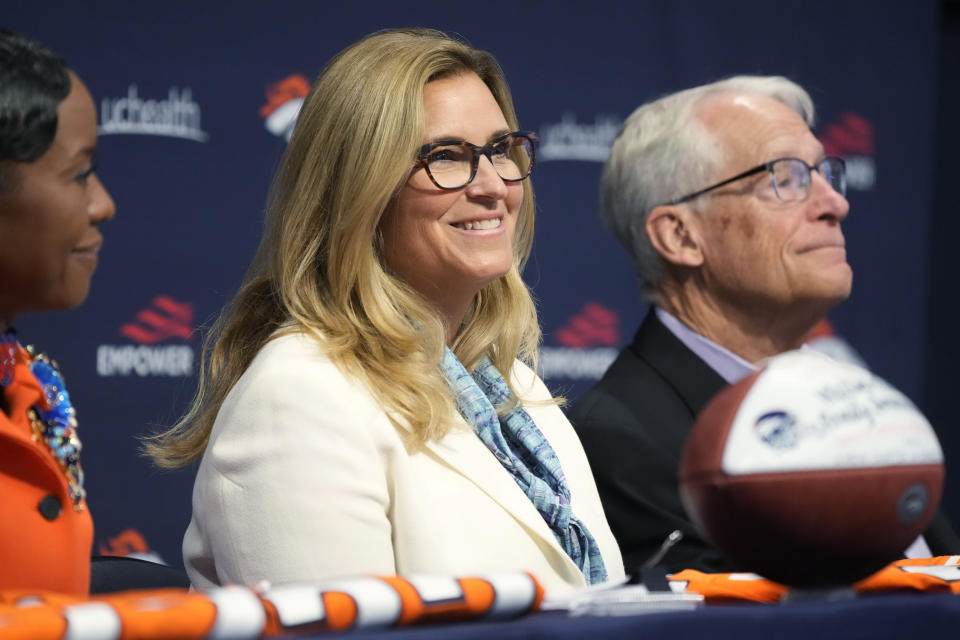 Rob Walton, back, joins his daughter Carrie Walton Penner, center, and limited shareholder Mellody Hobson, all members of the Walton-Penner Family Ownership Group that purchased the Denver Broncos, during a news conference at the NFL football team's headquarters Wednesday, Aug. 10, 2022, in Centennial, Colo. (AP Photo/David Zalubowski)