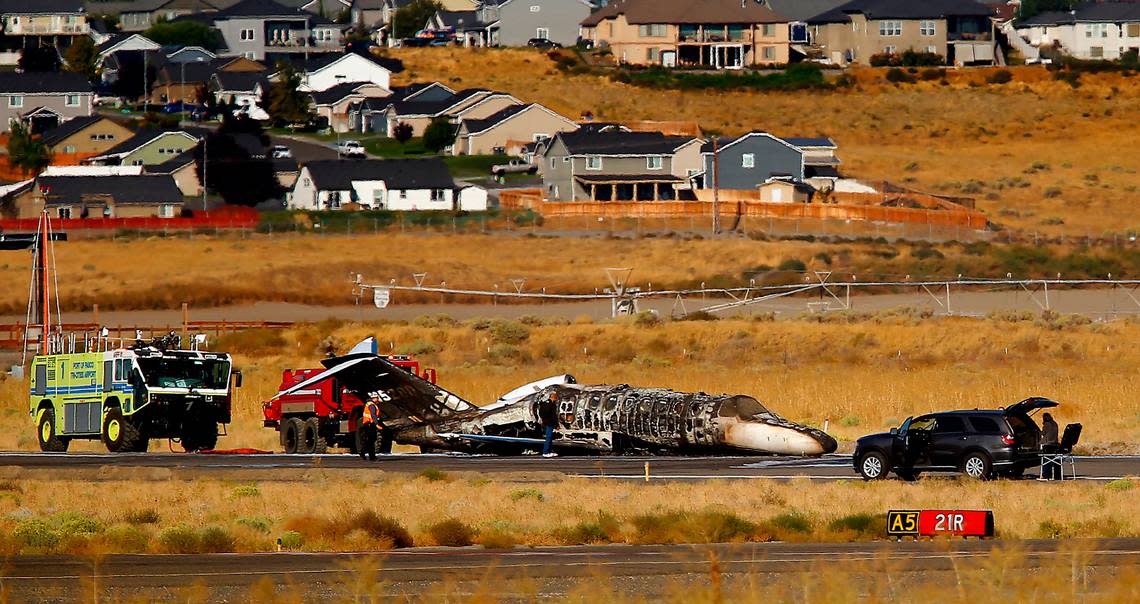 The charred remains of a privately owned small jet rests on a runway surrounded by emergency vehicles on Sept. 20, 2022 at the Tri-Cities Airport in Pasco. Passengers escaped before the plane burst into flames.
