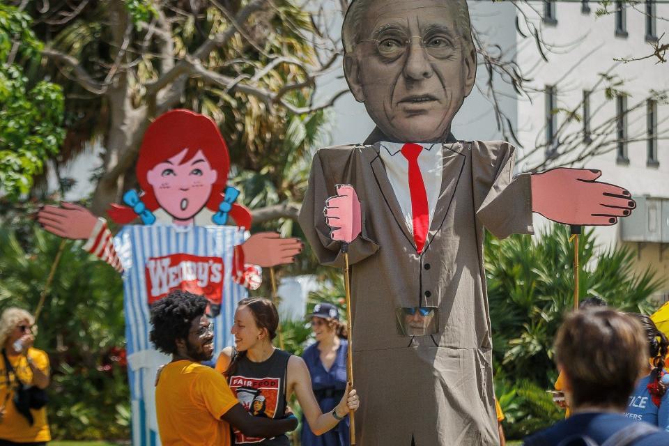 Frantzso Marcelin of Immokalee greets Lindsay Richards of Delray Beach April 2 at Bradley Park before the Coalition of Immokalee Workers' march through Palm Beach and West Palm Beach.