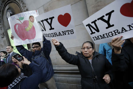 Demonstrators hold pro-immigration signs during a protest against Donald Trump in midtown Manhattan in New York City, April 14, 2016. REUTERS/Mike Segar