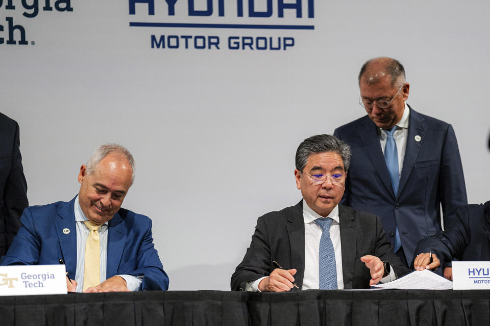 Georgia Tech President Ángel Cabrera, left, and Hyundai Motor Company CEO Jay Chang sign a new memorandum of understanding for future mobility collaboration during a ceremony at Georgia Tech in Atlanta, Tuesday, Sept. 19, 2023. (Matthew Pearson/WABE via AP)